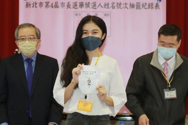 新北市市长侯友宜选举办公室政治实习生陈皓寧（中）为侯代抽候选人号次。（图／侯友宜办公室提供）