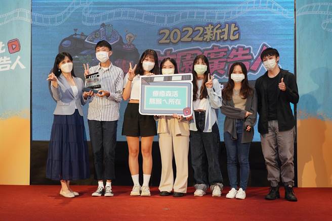 新北市新闻局长张爱晶（左）颁奖给以《疗癒森活熊猴ㄟ所在》作品获得首奖的辅仁大学的钟子棋、陈圣璇、王婷嫺、邓竺、吴海慈、邱晋暄。（新北市新闻局提供）