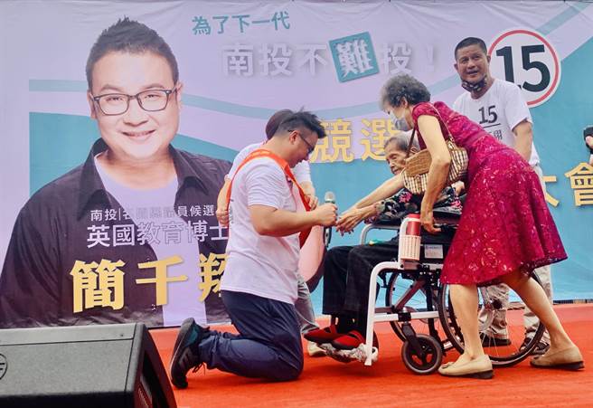 南投县议员候选人简千翔（左），由98岁的阿嬷帮他披挂彩带。（廖志晃摄）