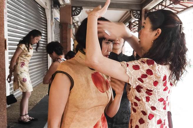 穿着復古旗袍的女子参加大稻埕国际艺术节1920变装活动，活动开始前相互整理髮型。（黄子明摄）