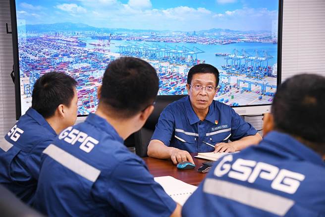 大陆自动化码头装卸效率屡创世界纪录，关键核心技术要不来买不到。图为山东省港口集团高级别专家张连钢（中）日前在青岛港与技术团队成员讨论。（新华社）