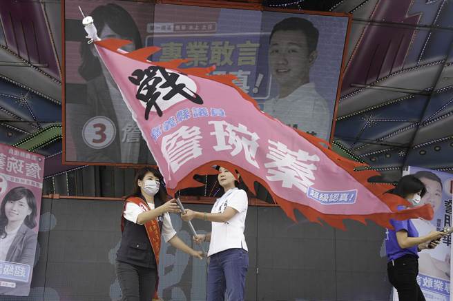 王育敏授战旗给同党籍嘉义县议员候选人詹琬蓁。（王育敏竞选团队提供∕吕妍庭嘉义传真）