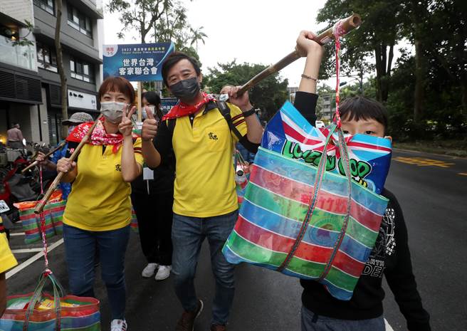 2022臺北客家义民嘉年华的「挑担奉饭」23日在台北市客家文化主题公园热闹登场，许多大人携手小孩一起挑担，传递客家义民信仰的精神及价值。（刘宗龙摄）