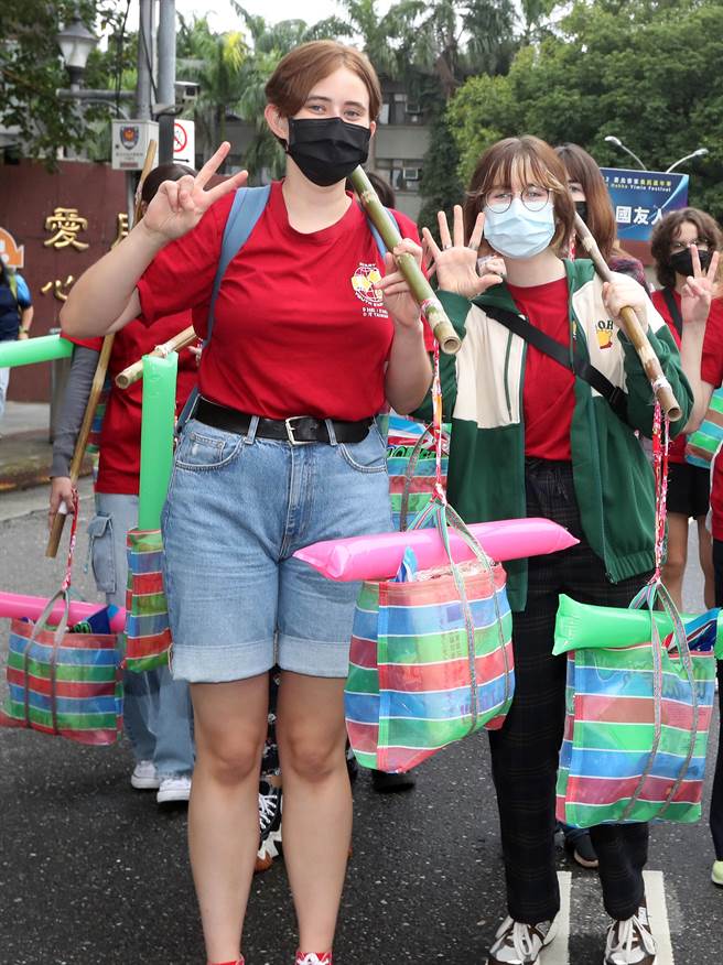 2022臺北客家义民嘉年华的「挑担奉饭」23日在台北市客家文化主题公园登场，外国朋友挑担踩街，体验感受客家义民信仰的精神及价值。（刘宗龙摄）