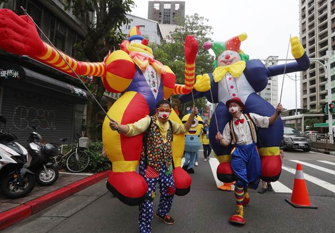 2022臺北客家义民嘉年华的「挑担奉饭」23日在台北市客家文化主题公园登场，魔术魂表演艺术团的成员操控两尊大型充气小丑踩街，让现场充满欢乐的气氛。（刘宗龙摄）