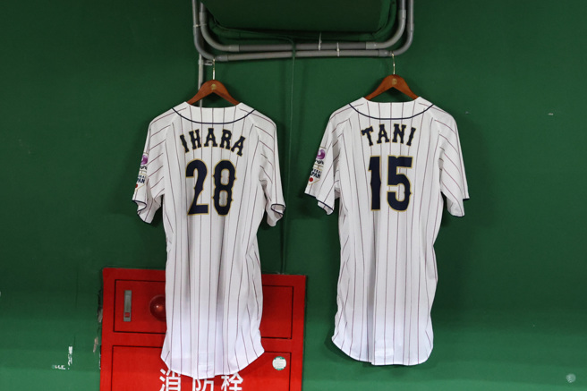 U23日本队谷优希、猪原隆雅在昨天做PCR时发现确诊，冠军战无法上场，队友带着他们的球衣来到冠军战。（中华棒协提供）