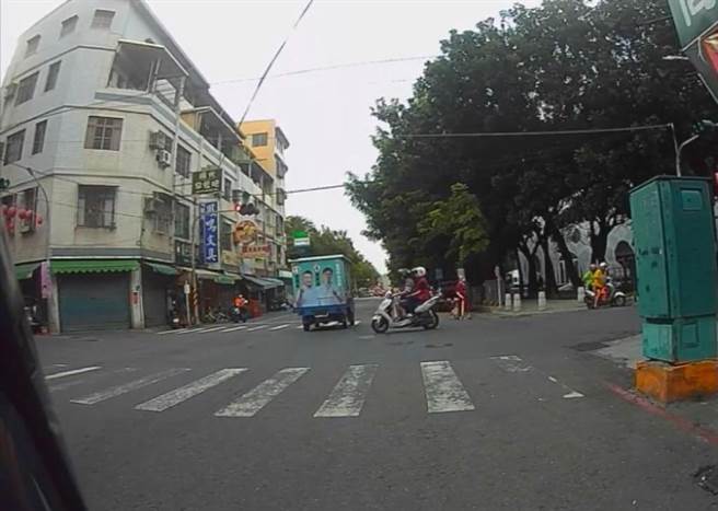 一辆白色机车要通过路口，机车赶紧从后方绕过宣传车，差点与宣传车直接撞上。（翻摄照片／杨舒婷高雄传真）