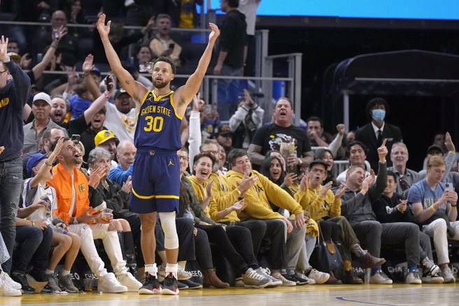 柯瑞投进三分球之后高举双臂庆祝。(美联社)