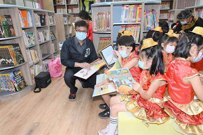 高雄市教育局長謝文斌（左）與學童打成一片，圖為廣興國小圖書館。（林瑞益攝）