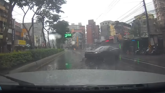 2车在路上竞速，左车副驾驶座的女子见状说「不要跟他玩啦，老公」，没想到下秒右侧跑车从外侧突打滑撞向分隔岛，车头撞烂停在路中。（翻摄自脸书「爆废公社二馆」）