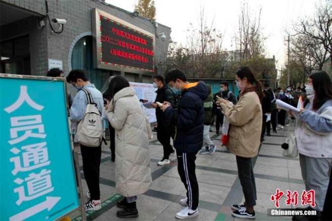 图为2020年北京一考点的国考考生排队等候入场。（中新社）