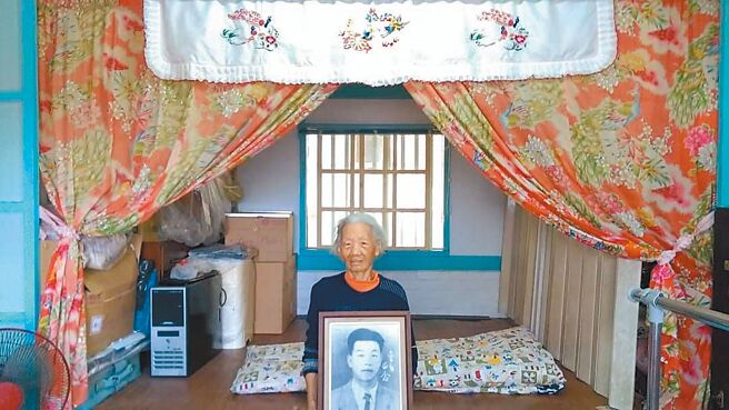 八二三阵亡烈士遗孀曾妈妈，抱着丈夫的遗照说：「他永远二十九岁，我却九十二岁了。」（王琼玲提供）