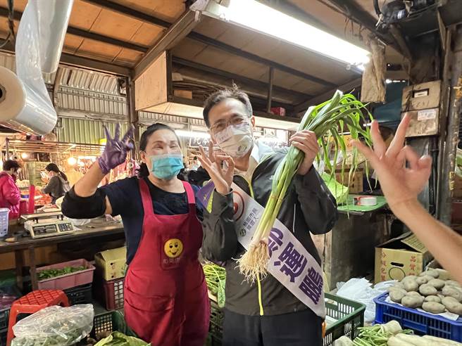 民进党桃园市长候选人郑运鹏26日到力行市场扫街拜票，摊商送上白萝卜跟蒜祝他好彩头跟「冻蒜」。(蔡依珍摄)