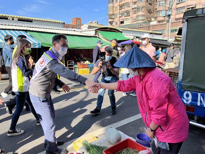 民进党桃园市长候选人郑运鹏26日到力行市场扫街拜票，摊商送上白萝卜跟蒜祝他好彩头跟「冻蒜」。(蔡依珍摄)
