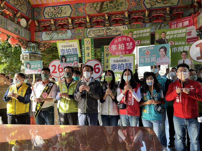 民进党桃园市长候选人郑运鹏26日到力行市场扫街拜票前，和党籍市议员候选人一起到永安宫上香祈福，希望能「全垒打」。(蔡依珍摄)