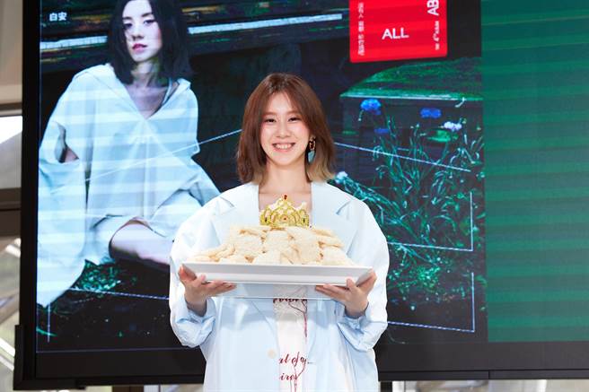 白安今在記者會上吃鍋巴慶祝新專輯攻下數位排行榜11個冠軍。（相信音樂提供）