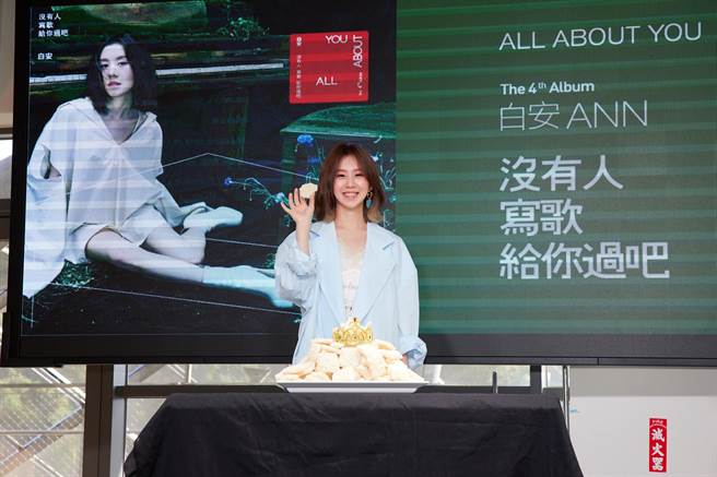 白安今在記者會上吃鍋巴慶祝新專輯攻下數位排行榜11個冠軍。（相信音樂提供）