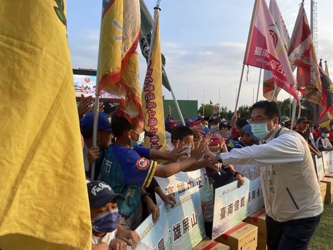 黄伟哲和在场的球员击掌打气。（李俊淇摄）