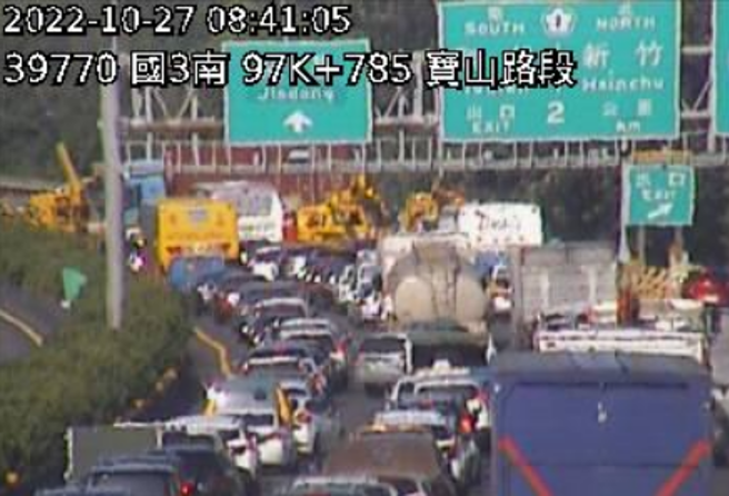 国道3号南向98.5K、新竹宝山交流道处今（27日）上午8时许发生一辆货柜车与8辆轿车追撞事故，事故现场占据4个车道，后方车流回堵约1公里。（翻摄自国道即时车况资讯）