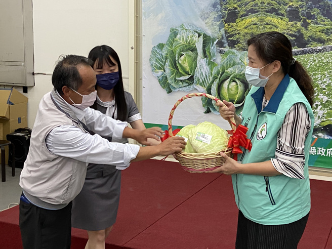 由农粮署东区分署署长徐辉妃（右)与大同乡蔬菜产销班第十六班班长高万年（左），一同象徵性贴上有产销履歷认证的贴纸。（吴佩蓉摄）