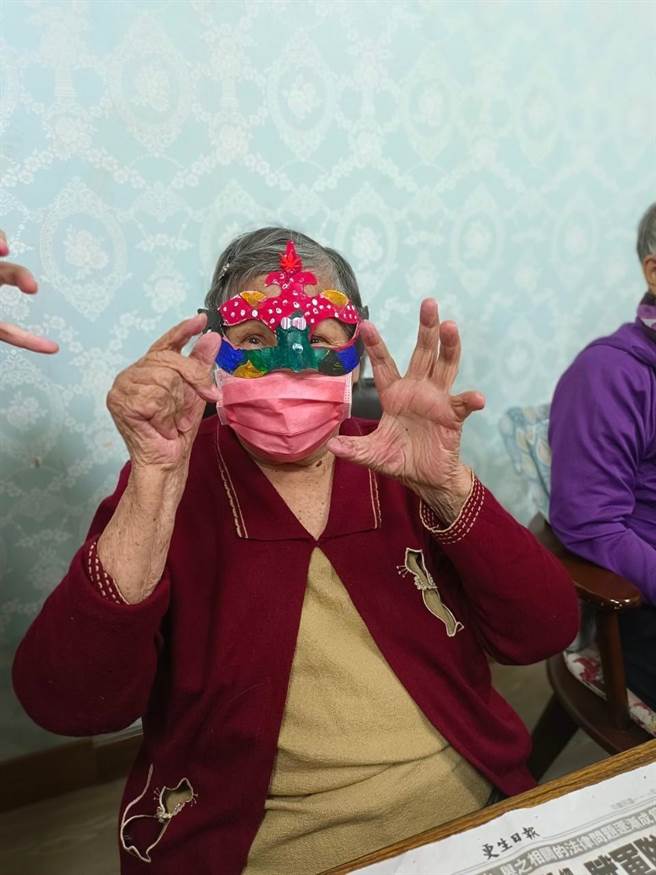 花莲老家协会乐智据点的失智长者们，万圣节前夕在慈大学生带领下，绘制专属自己的「搞怪面具」，完成后更迫不及待地戴上。（花莲老家协会提供／罗亦晽花莲传真）