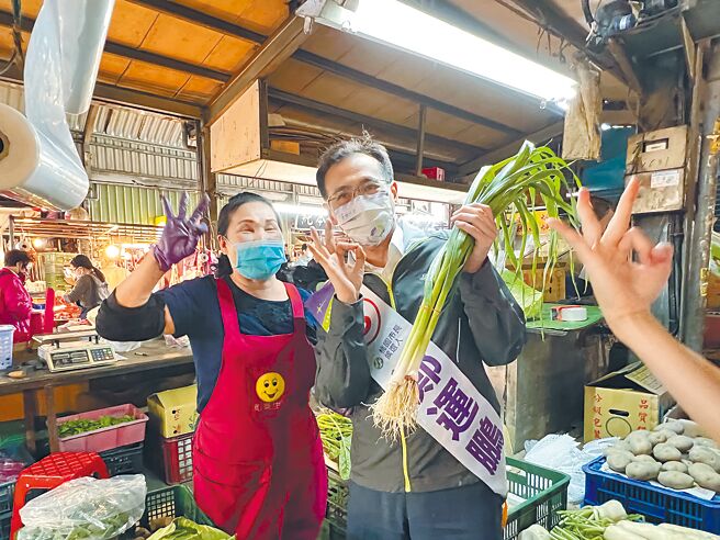 民進黨桃園市長候選人鄭運鵬26日到力行市場掃街拜票，攤商送上白蘿蔔跟蒜祝他「好彩頭」跟「凍蒜」。（蔡依珍攝）