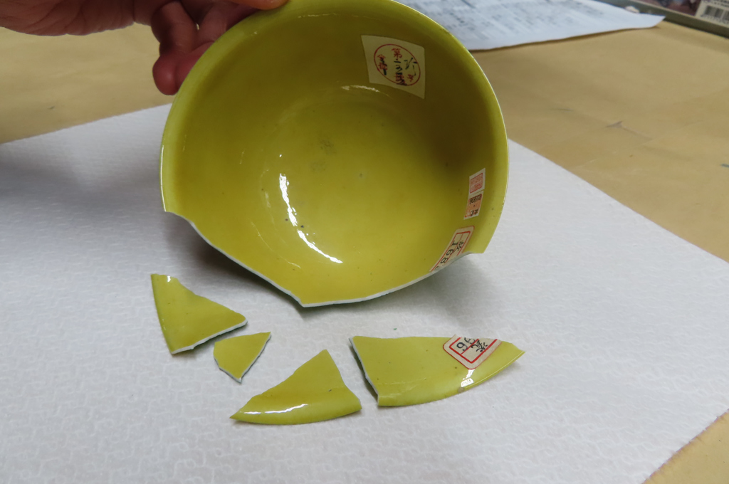 「明弘治款嬌黃綠彩雙龍小碗」碎裂成4片。(圖／故宮提供)