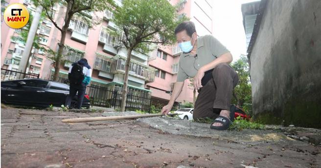 陈姓屋主带着本刊到屋外的人行道查看，原本平坦的路面如今也变得凹凸不平。（图／赵世勋摄）