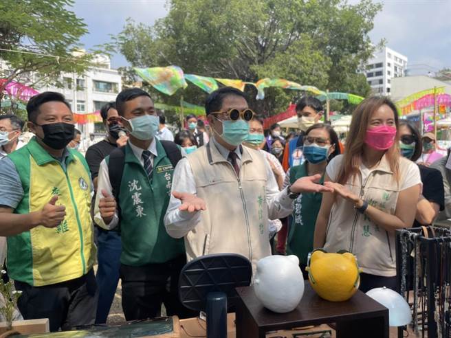 市长黄伟哲逛到手作眼镜摊前，拿起眼镜试戴。（李俊淇摄）