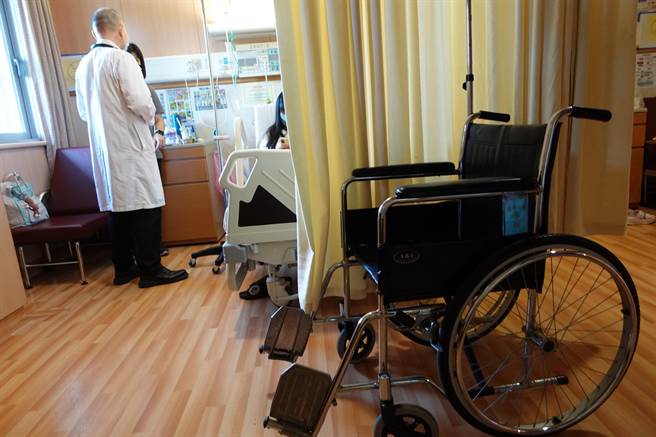 小澄罹患「横纹肌溶解症」，住院期间必须使用轮椅行动，小儿科主任李敏骏（左）查房时跟家人说明治疗进度。（台中慈济医院提供）