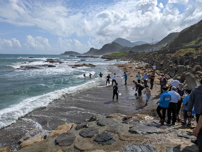 基隆區漁會、台電公司共同舉辦魚苗放流，吸引許多民眾與學子一起合作傳遞魚苗放流入海。（張志康攝）