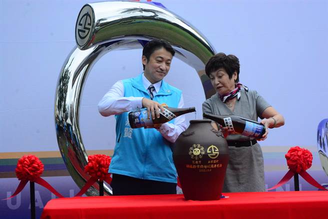 市长魏嘉贤与市代会主席苏美珠，透过视讯，与纟数健一和议长崎元俊男分两地同步将与那国町酿制纪念酒倒入特制酒瓮里，后方则是艺术装置「约定」。（王志伟摄）