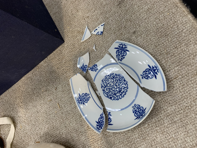 「清乾隆青花花卉盘」因工作人员处理不慎，从高处摔落之故，当成裂成7片大小不均的碎片。(图／故宫提供)