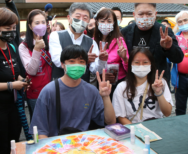 进党台北市长候选人陈时中（后右三）28日出席在四四南村举行的全国身心灵职业工会誓师大会，在参观摊位时，和民眾开心合影留念。（赵双杰摄）