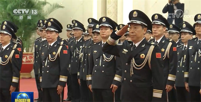 图为陈文清向习近平敬礼，从习近平手中接过中国人民员警警旗。(资料照／央视)