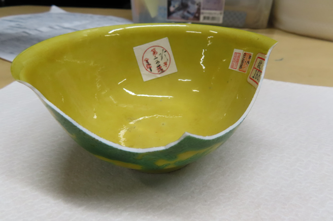 明弘治款娇黄绿彩双龙小碗破损情形。（国立故宫博物院提供）