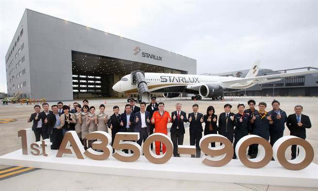 董事長張國煒（著橘色飛行連身服）與接機團隊合影留念。（范揚光攝）