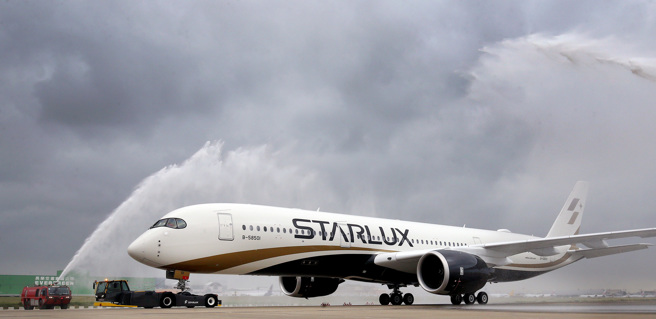 星宇航空首架空中巴士A350-900型客機29日抵台，機場公司派出2輛消防水車為新機舉行象徵好運的灑水儀式。（圖／范揚光攝）