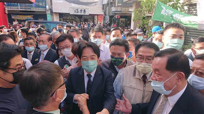 副总统赖清德（黑西装深蓝领带者）回娘家参拜庙宇兼辅选黄伟哲，受民眾夹道欢迎。（程炳璋摄）