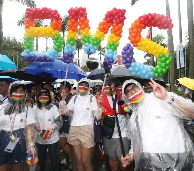 第20屆台灣同志遊行以「無‧限．性」為主題29日登場，參加遊行外商員工代表手持紅、橙、黃、綠、藍、紫紮出來的「BMS」氣球牌，行動支持台灣更加友善環境。（陳怡誠攝）