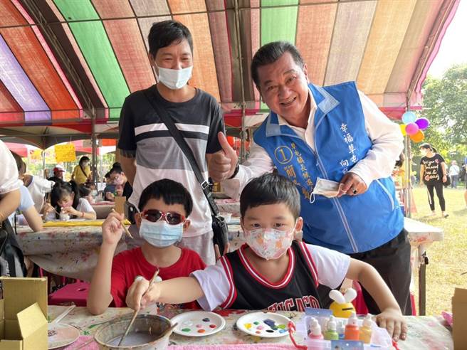 「2022稻草工藝文化節」29日盛大開幕，草屯鎮長簡景賢看到孩子發揮創意彩繪幸福瞇兔，豎起大拇指比讚。（楊靜茹攝）