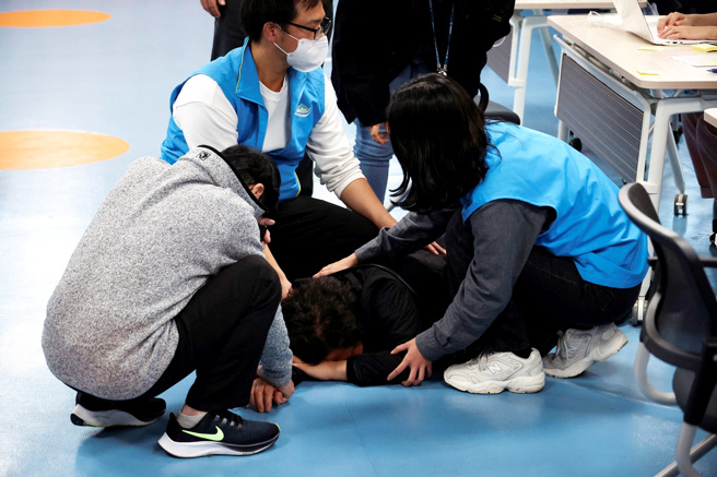 南韩首尔梨泰院万圣节踩踏事件有超过3000人失踪，许多家长哭着一家一家医院寻找失踪儿女。图为家长在首尔一间社区服务中心哭倒在地。（图／路透社）