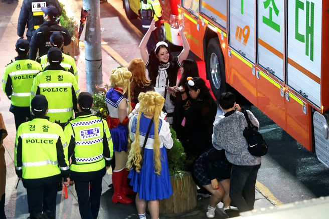 梨泰院29日发生大规模踩踏事件后，狂欢女子仍在周边聚集。（图／路透社）