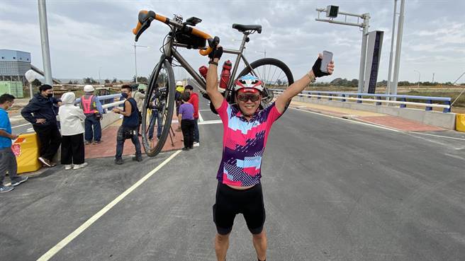 來自金湖鎮新市里的何先生騎單車率先過橋，成為正式通車後過橋的第一人， 開心的舉起單車大聲喊「爽」(于家麒攝)