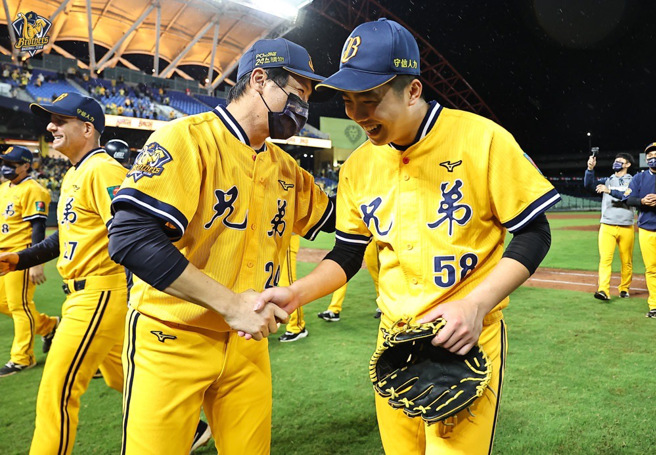 中信兄弟在季后挑战赛淘汰味全龙，总教练林威助（左）与终结者吕彦青握手庆贺。（中信兄弟提供）