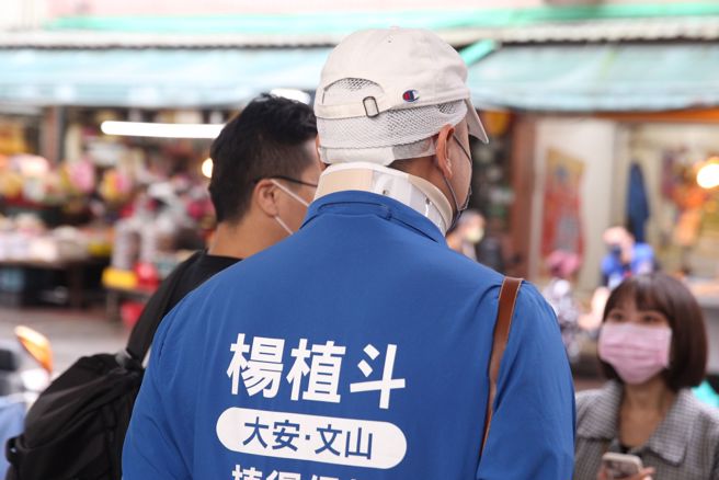 前总统马英九1日陪同日前摔破脑袋的国民党大安文山市议员候选人杨植斗前往木栅市场拜票，杨植斗扫街时头上仍包扎着。(杜宜谙摄)