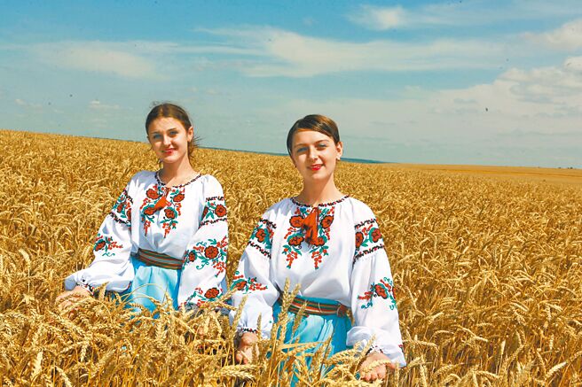 圖為身穿民族服裝的烏克蘭少女參加糧食收割儀式的資料照片。（新華社）