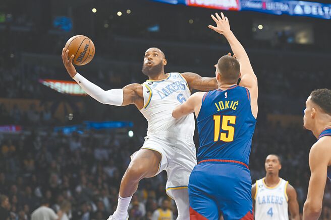 詹姆斯（左）一手拨开约基奇，另一手准备单手挑篮取分。（美联社）