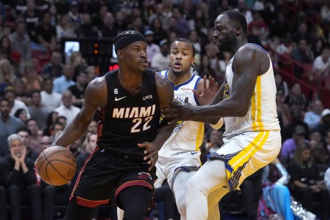 热火吉米巴特勒(左)持球对抗勇士球员包夹。（美联社）