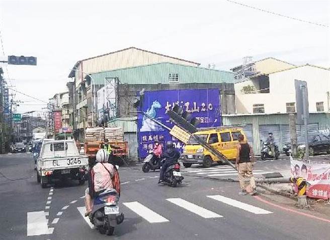 东势区上午发生一辆大货车，行经泰昌街与东坑路口时，因上方的吊杆不慎勾到电线，间接造成号志杆被折断的意外。(警方提供)